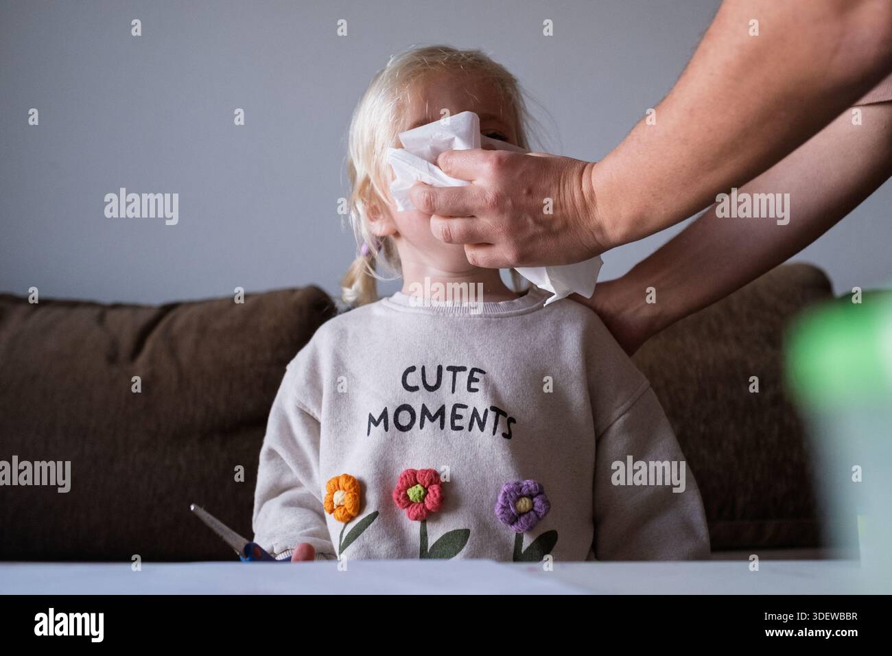 Mère prenant soin d'un enfant malade souffrant de grippe ou d'allergie, nettoyant le nez avec un mouchoir. Banque D'Images