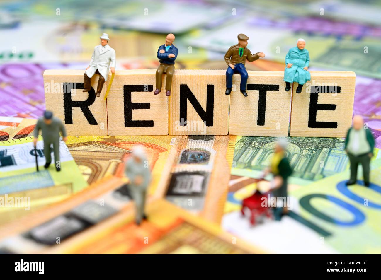 Figurines miniatures assis sur le lettrage pension sur les billets en euros Banque D'Images