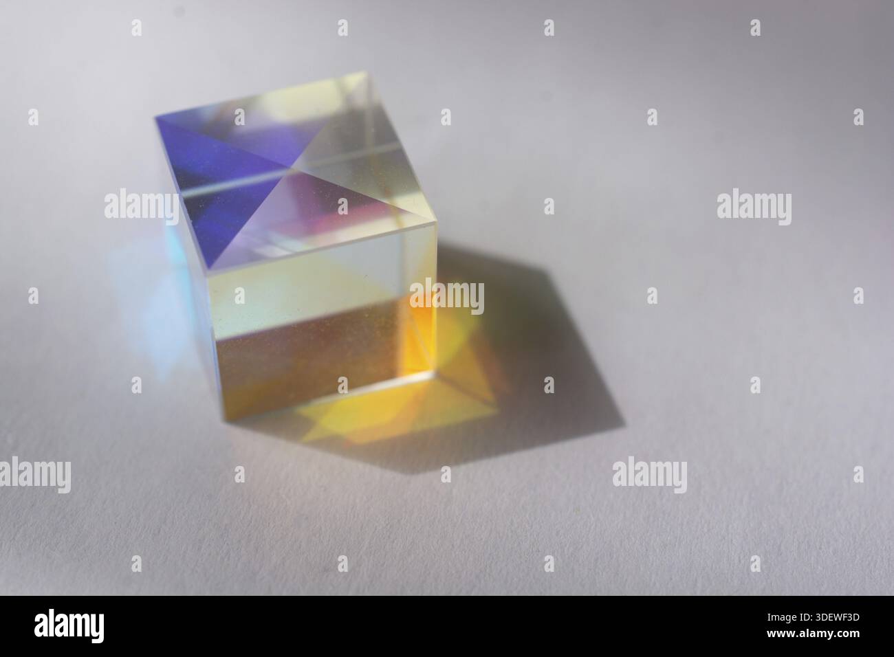Les cubes de verre optique diffusent la lumière spectrale avec toutes les couleurs de l'arc-en-ciel sur la surface Banque D'Images