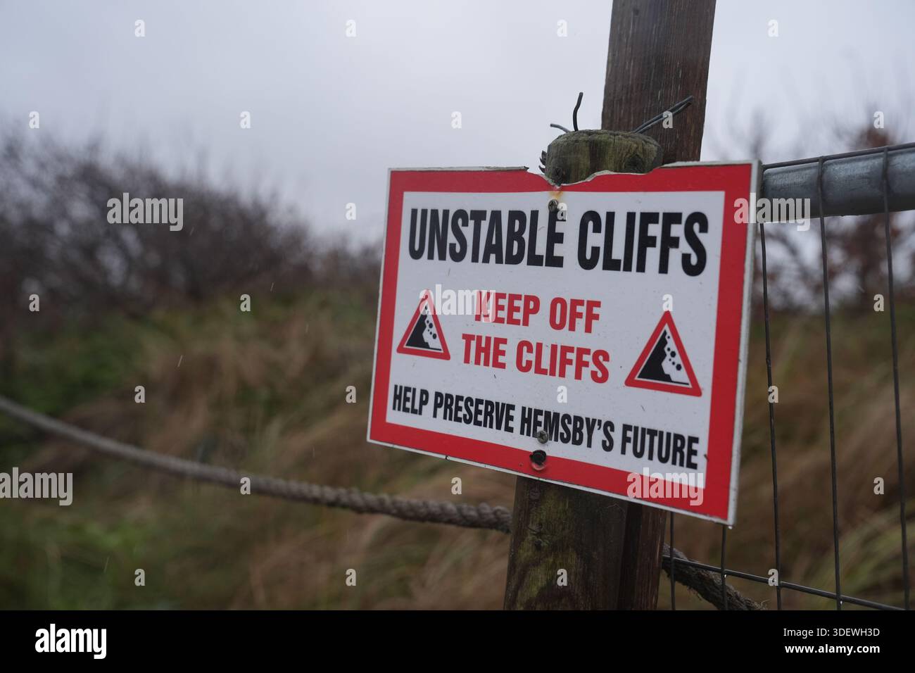 Un panneau d'avertissement vu alors que les propriétés commencent à être démolies près du bord de la falaise à Hemsby dans le Norfolk qui sont à risque de s'effondrer lorsque les marées hautes coupent en falaises sablonneuses. Date de la photo : vendredi 9 janvier 2026. Banque D'Images