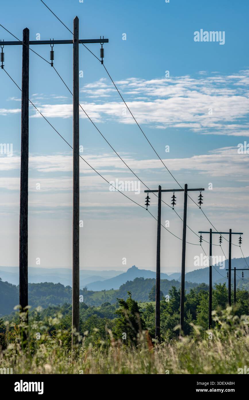 Lignes électriques s'étendant à travers un paysage rural avec des collines. Banque D'Images