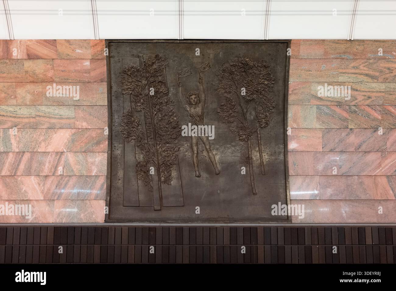 Relief en bronze dans la station de métro Anděl à Prague. Art de l'amitié tchécoslovaque-soviétique. Une personne brandissant deux drapeaux de Moskva (Moscou) et Prague. Banque D'Images