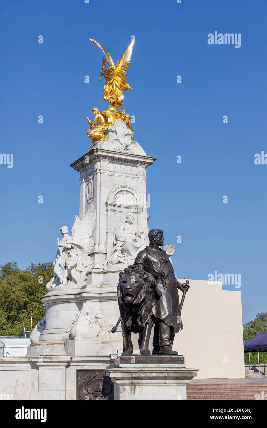 Victoire ailée statue dorée et homme en bronze avec lion sur le mémorial de la reine Victoria à l'extérieur du palais de Buckingham, Londres, Angleterre, Royaume-Uni Banque D'Images