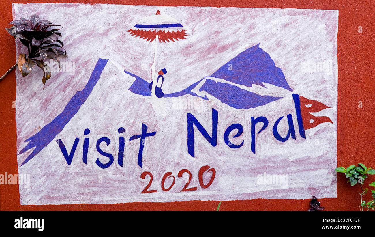 Murale artistique avec les mots « Visit Nepal » avec des lettres décoratives et une peinture vibrante sur une surface urbaine. Banque D'Images