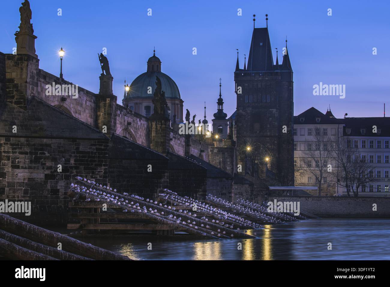 Vue de la silhouette sombre du pont Charles s'élève contre le bleu profond du crépuscule, avec des statues debout la garde au-dessus de la rivière Vltava, Prague, Banque D'Images