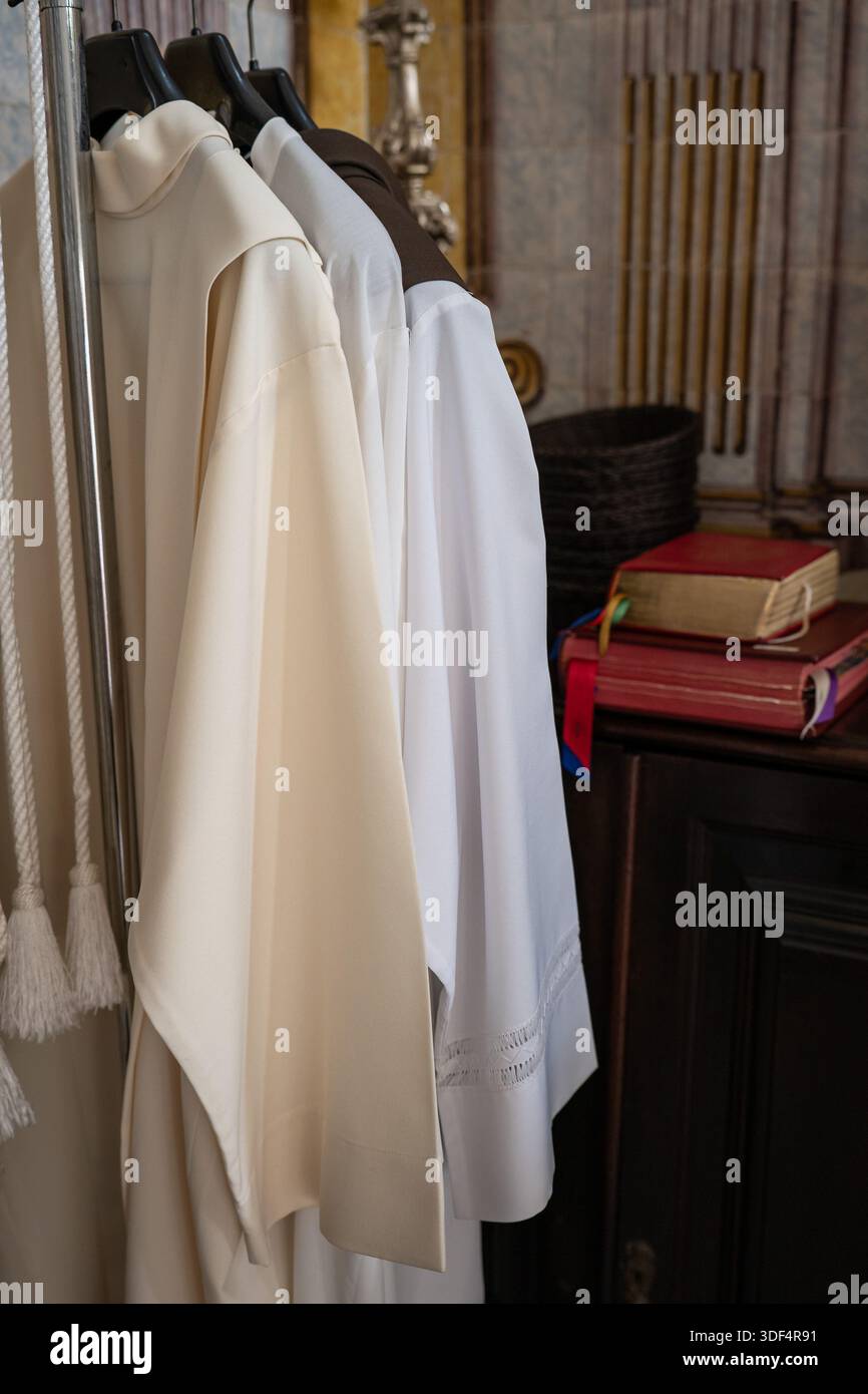 Surplice de Fiew prêtre, vêtements liturgiques sur un cintre, Sainte écriture en arrière-plan Banque D'Images