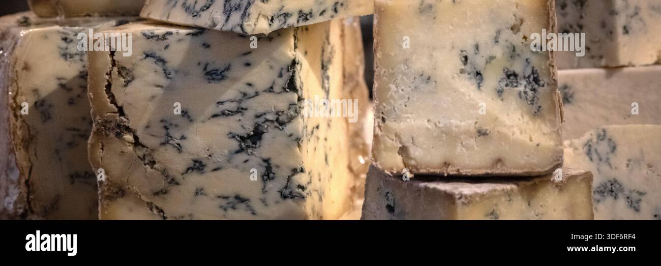 Panorama de quartiers de fromage bleu Stilton sur un étal de fromagers sur un marché alimentaire Banque D'Images