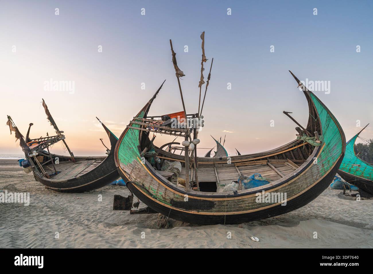 Vue de paysage de bateaux de pêche traditionnels en bois connus sous le nom de bateaux de lune reposant sur le sable près de la plage d'Inani avant le coucher du soleil, Cox's Bazar, Bangladesh Banque D'Images