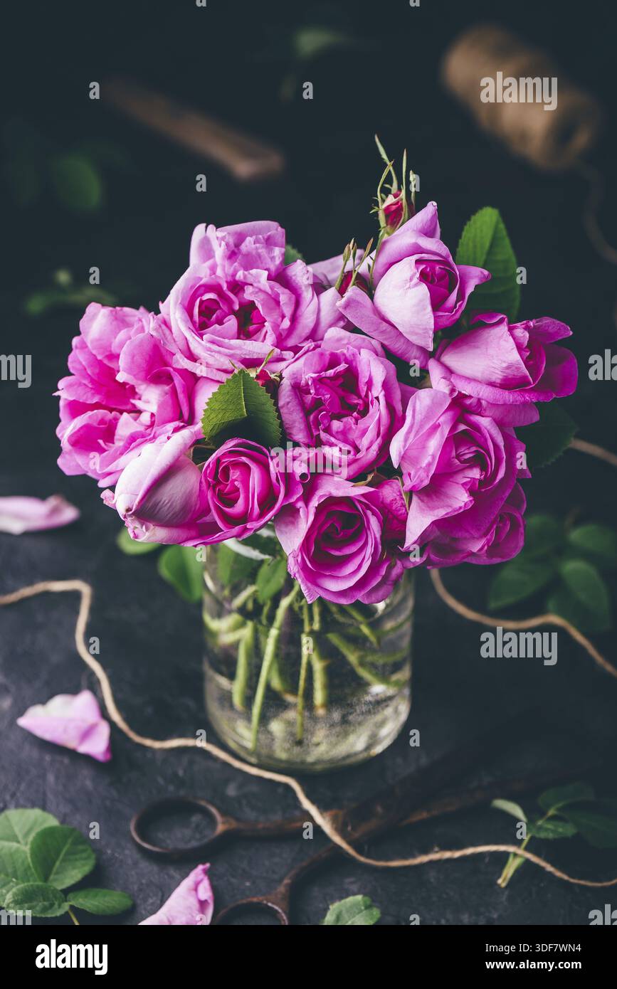 Bouquet de petites roses de jardin en bocal avec eau Banque D'Images
