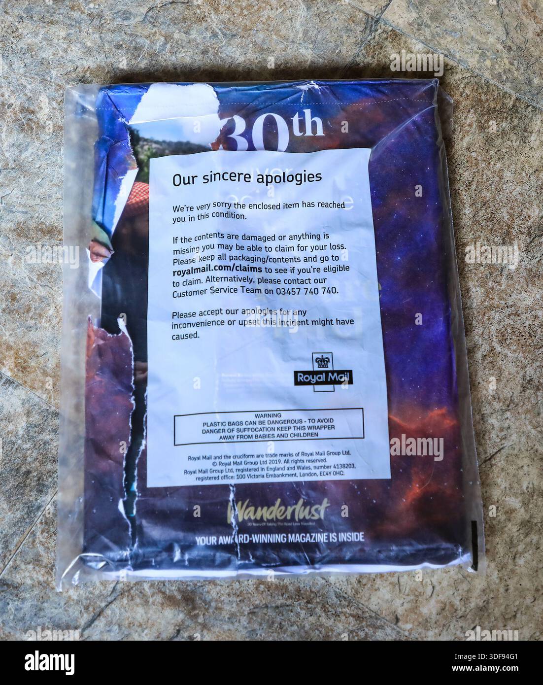 Un magazine dans un colis de livraison livré par Royal mail et endommagé en transit, Angleterre, Royaume-Uni Banque D'Images