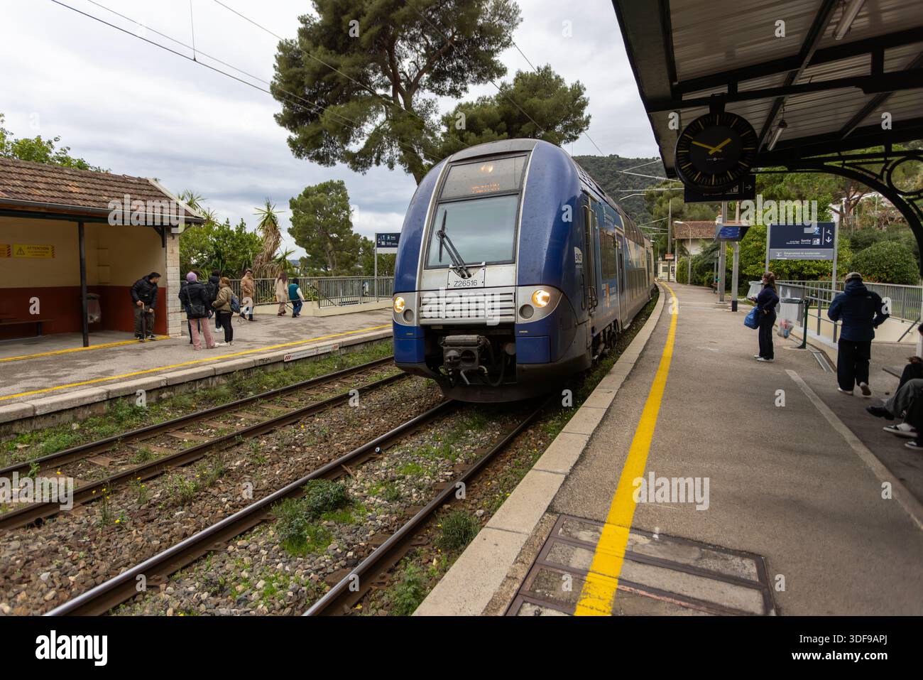 Eze, France -22 décembre 2025 : un train de transport express régional (TER) par SNCF arrive à la gare d'Eve en provenance de Monaco. Banque D'Images