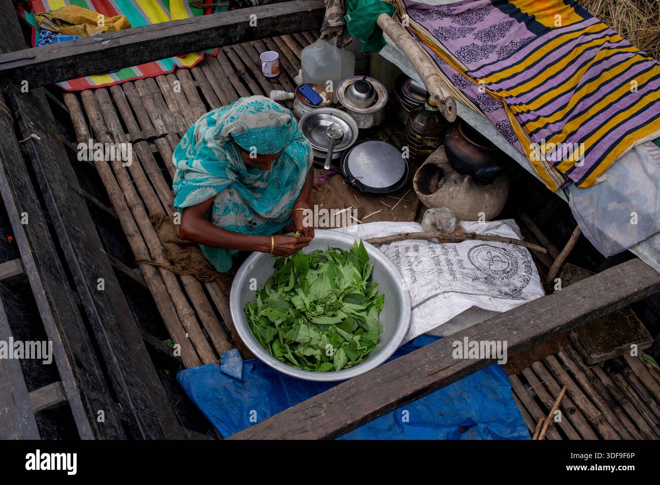 Les gens se réfugient sur des bateaux alors que les inondations submergent des maisons dans une zone de charpente le long de la rivière Jamuna à Sariakandi, Bogura, Bangladesh. Banque D'Images
