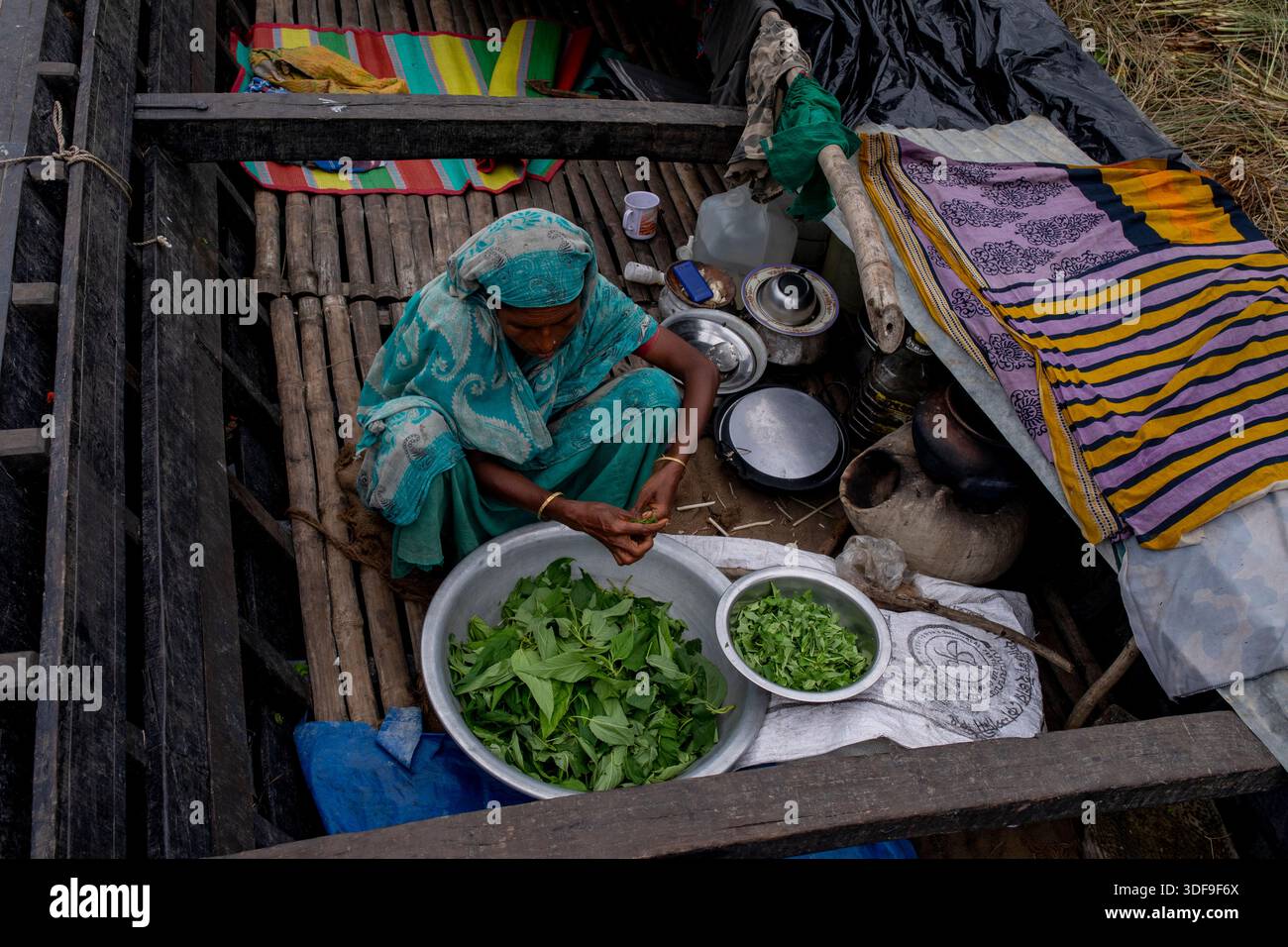 Les gens se réfugient sur des bateaux alors que les inondations submergent des maisons dans une zone de charpente le long de la rivière Jamuna à Sariakandi, Bogura, Bangladesh. Banque D'Images