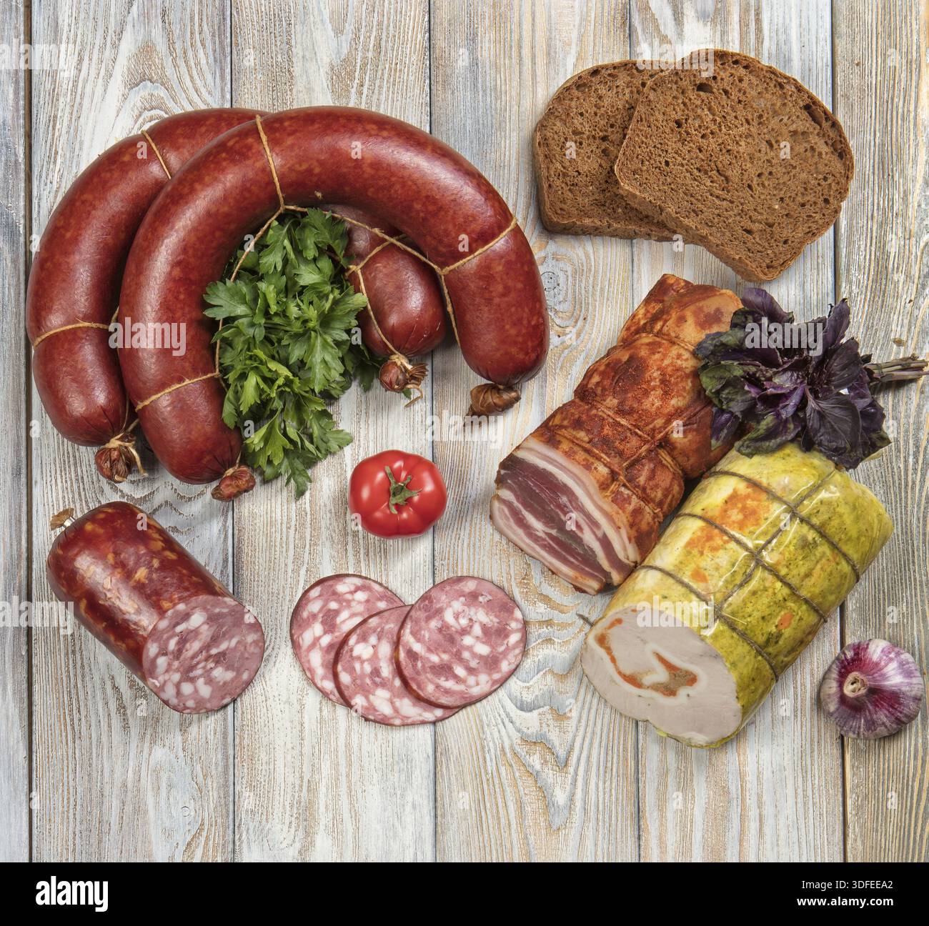 Différents types de saucisses avec des légumes sur une table en bois Banque D'Images