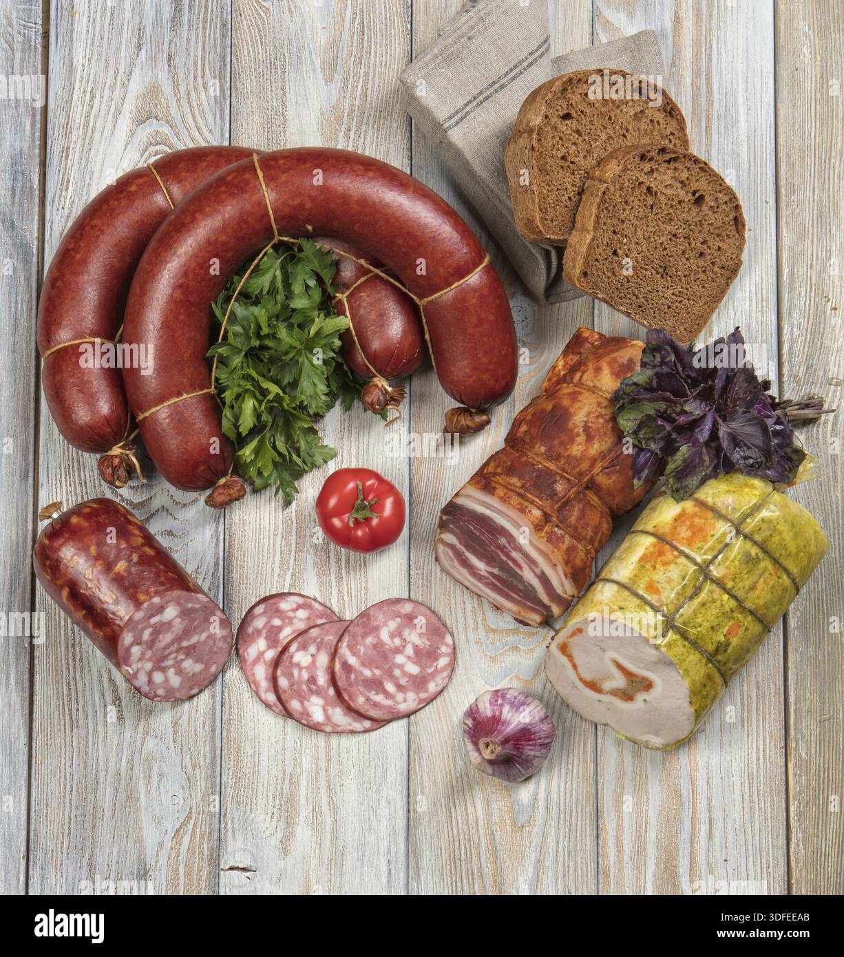 Différents types de saucisses avec des légumes sur une table en bois Banque D'Images