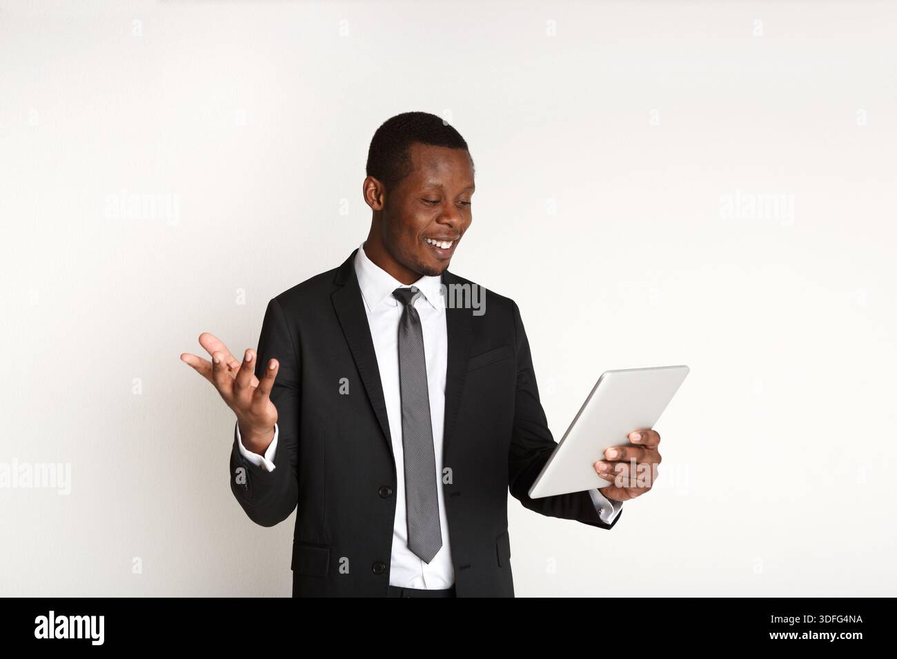 Homme d'affaires afro-américain souriant à l'aide de la tablette. Banque D'Images