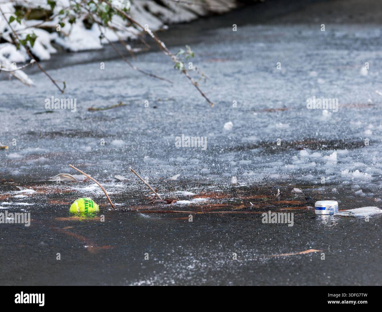 Déchets plastiques flottants piégés sous la surface de l'eau glacée, conditions hivernales, pollution de l'environnement, écosystème d'eau douce, temps froid, impact humain. Banque D'Images