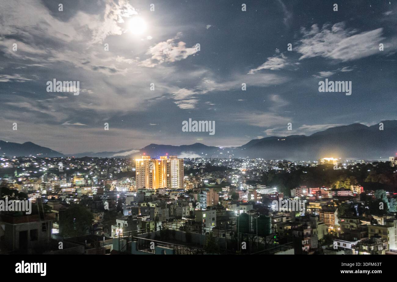 Lune brillante au-dessus de la ville la nuit Banque D'Images