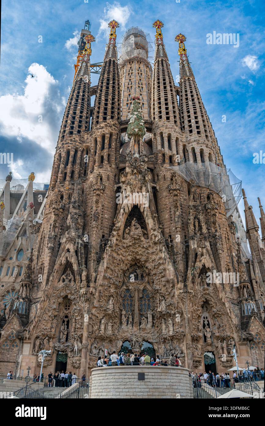 Barcelone, Espagne - 19 octobre 2025 : vue en bas angle de l'imposante façade de la Nativité de la basilique de la Sagrada Familia sous un ciel bleu. Banque D'Images