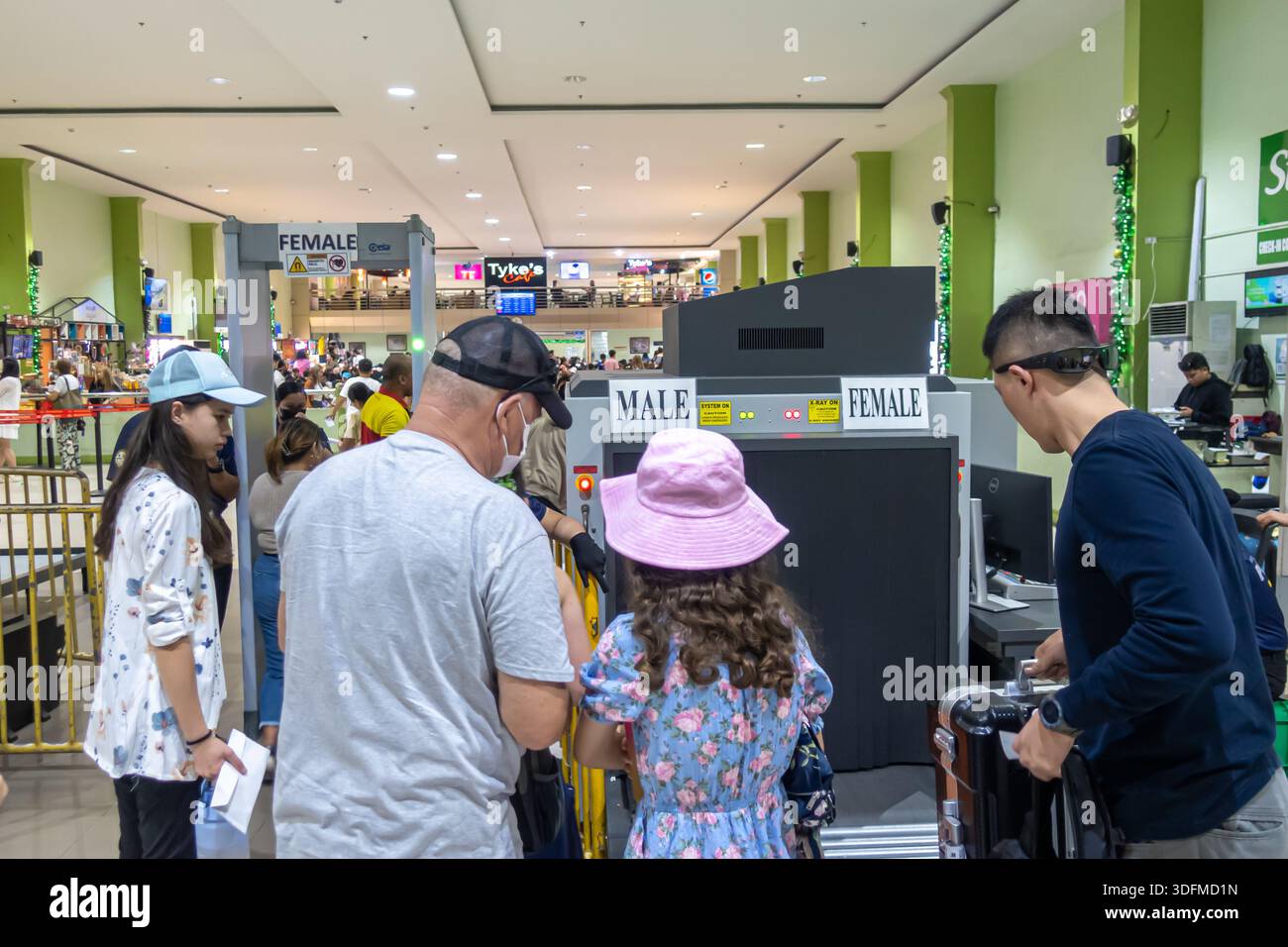 Passagers passant par l'équipement de contrôle de sécurité, détecteurs de métaux marqués pour les voies masculines et féminines. Poste de contrôle de sécurité terminal de ferry Cebu Banque D'Images