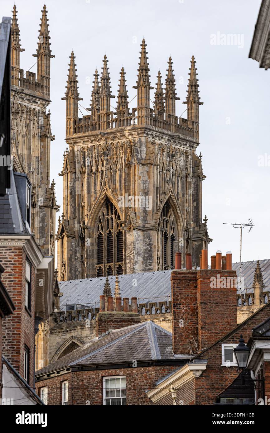 L'architecture gothique domine la scène, avec une imposante cathédrale en pierre ornée de flèches et de détails complexes, partiellement obscurcie par un bric au premier plan Banque D'Images