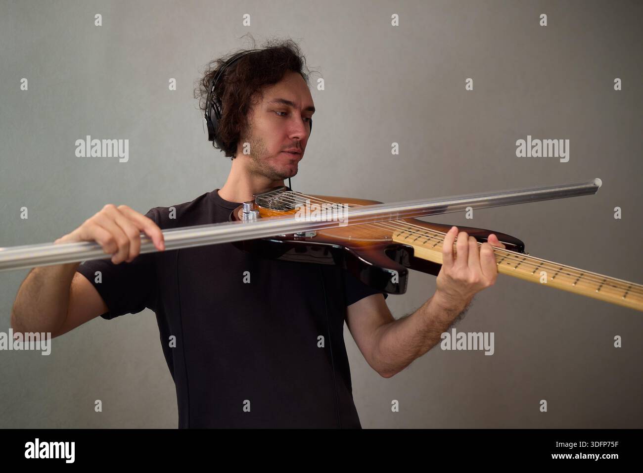 Performance basse puissante, performeur dynamique communiquant passionnément par le biais de la guitare basse, musicien aux cheveux bouclés immergé dans des basses expressives Banque D'Images