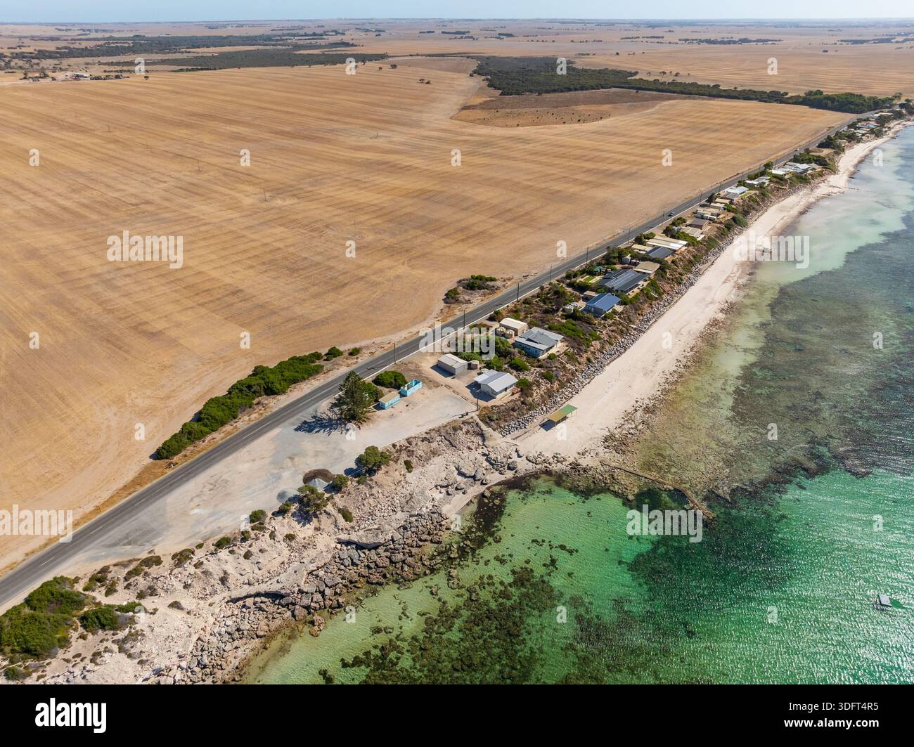Vue aérienne de terres agricoles derrière un rond côtier et une petite communauté au-dessus de la plage à point Turton sur la péninsule de Yorke en Australie méridionale. Banque D'Images