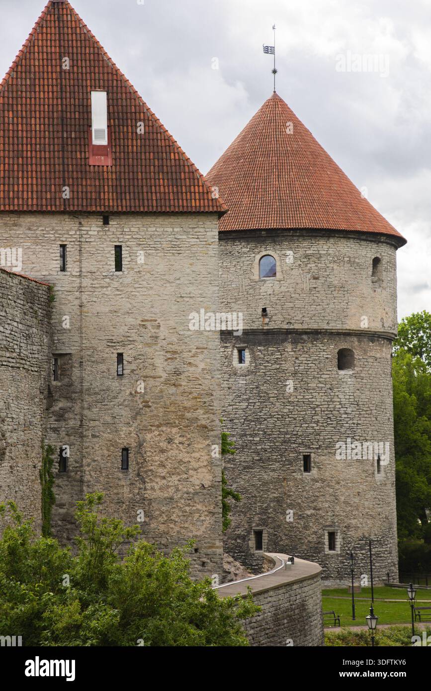 Tallinn, Estonie - 07 juin 2025 : vue sur les anciens remparts et tours de la ville, où la pierre altérée rencontre les toits rouges éclatants sur fond de clo Banque D'Images