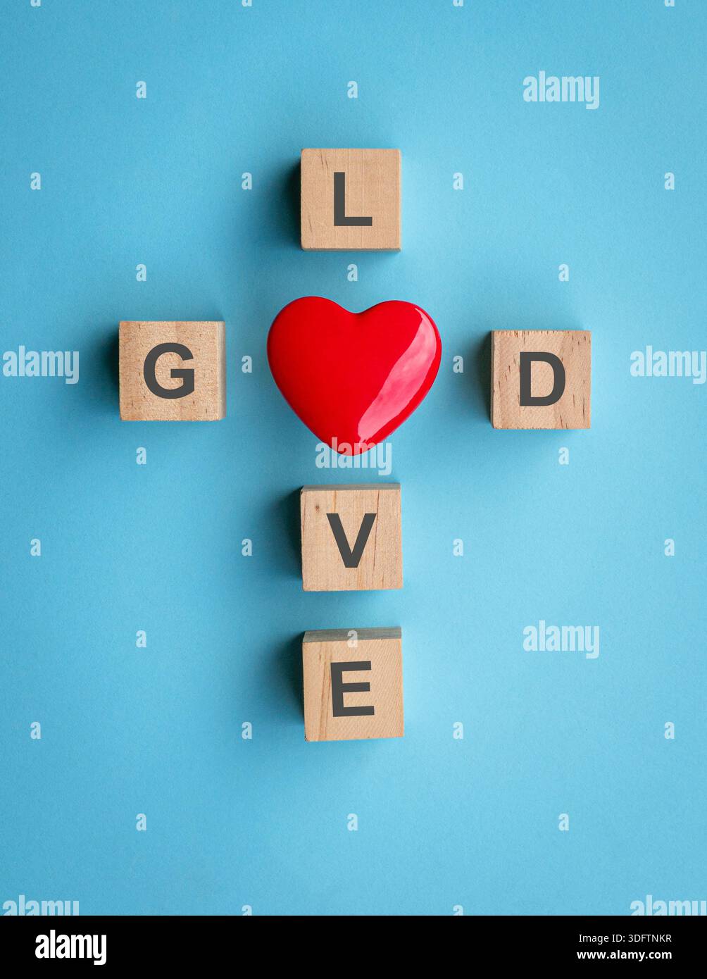 Texte sur blocs de bois avec forme de coeur rouge, sur fond bleu. Dieu est concept d'amour. Banque D'Images