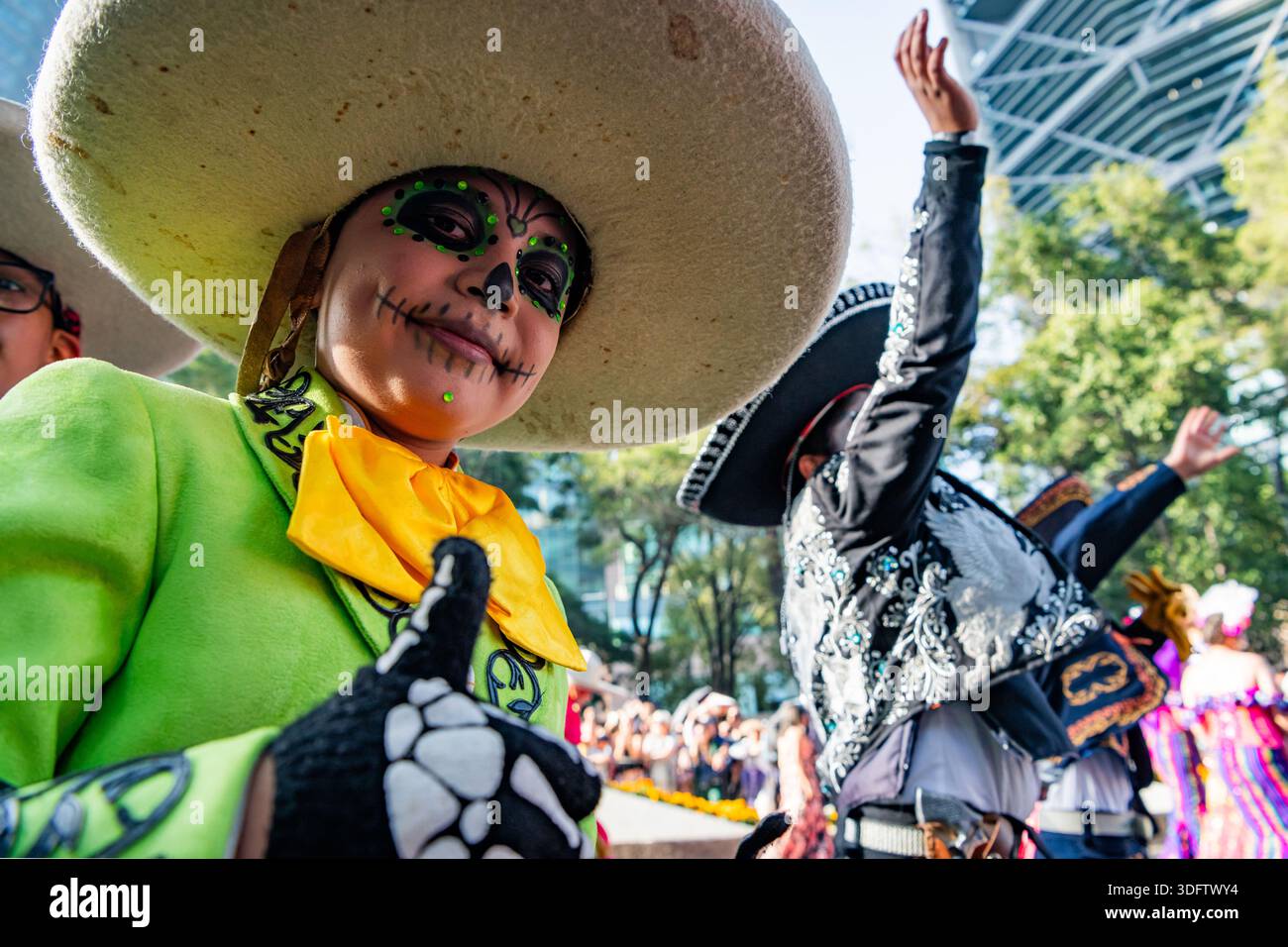 Mexico, Mexique - 04 novembre 2023 : vue sur les costumes vert citron et les visages peints au milieu de la parade du jour des morts, où les traditions éclatent Banque D'Images