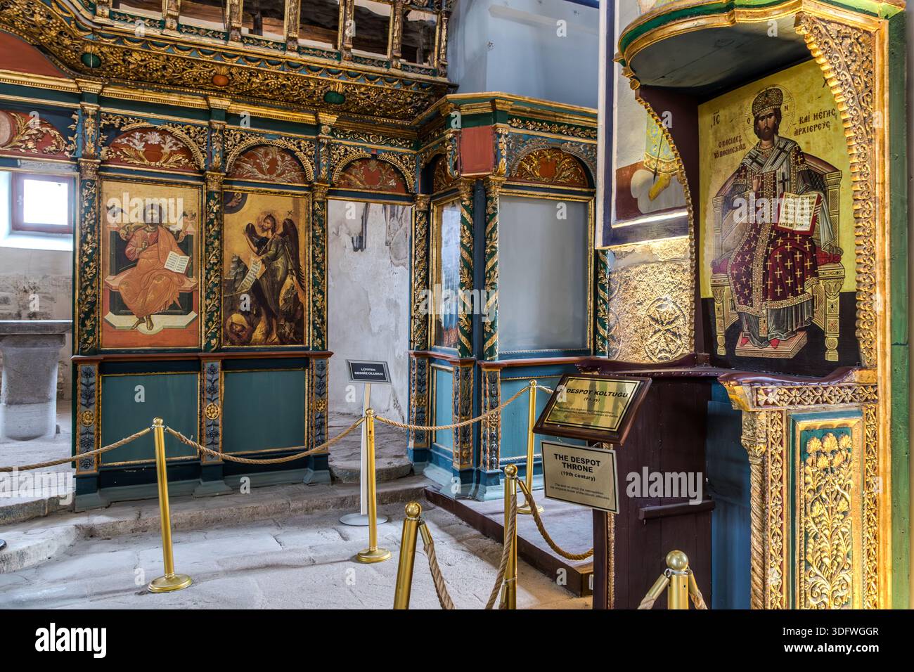Un panneau identifie le „Trône du despote“ dans l'église Hagia Eleni à Sille près de Konya, en Turquie, sur dont le mur arrière arbore une icône du Christ trônant en tant que souverain et grand prêtre. À droite, une porte ouverte mène à une pièce adjacente décorée de fresques. Banque D'Images