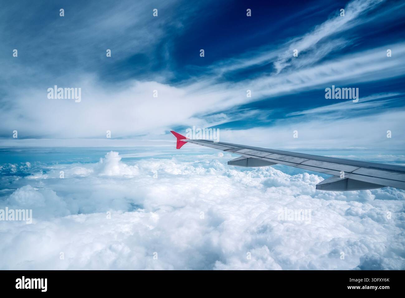 Nuages moelleux vus à travers la fenêtre d'un avion. Vue depuis la fenêtre de l'avion sur un beau ciel nuageux et l'aile de l'avion. Banque D'Images