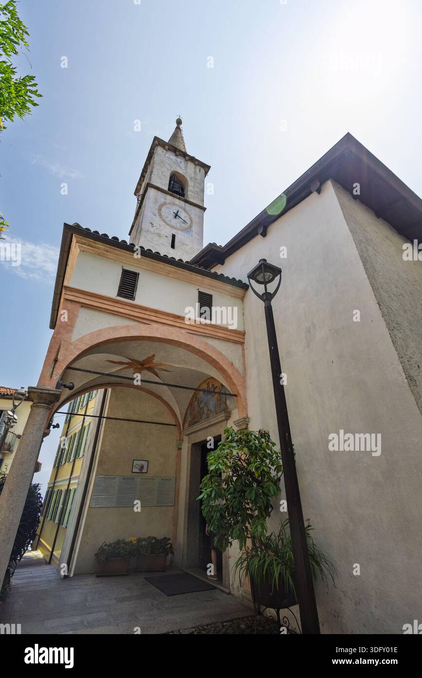 ISOLA DEI PESCATORI, ITALIE, 06.21.2025 :Une rue européenne ensoleillée dispose d'une tour d'horloge historique, d'une entrée voûtée et d'une façade accueillante. PE Banque D'Images
