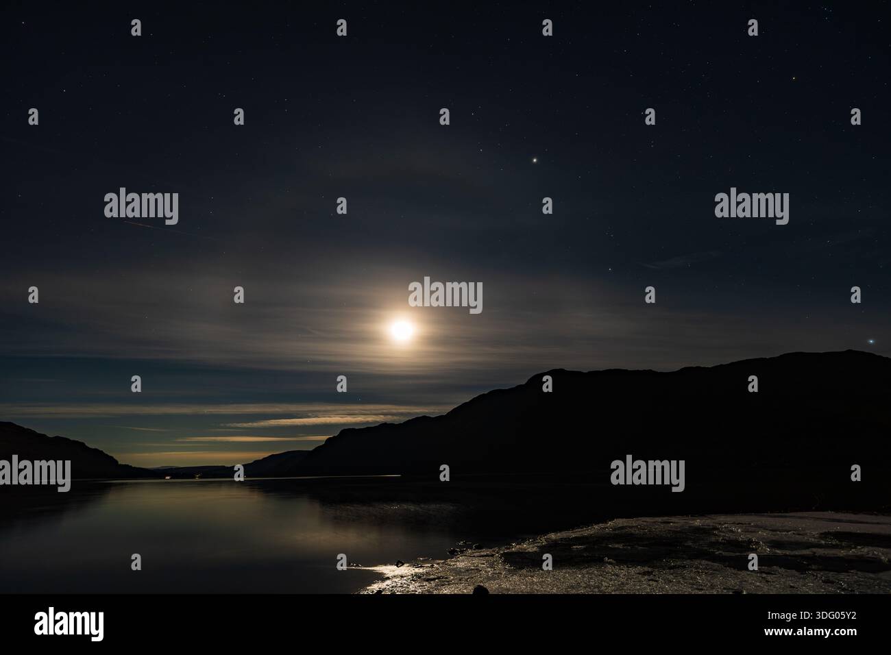 Une vue de la Lune projetant un arc-en-lune sur Ullswater dans le Lake District anglais Banque D'Images