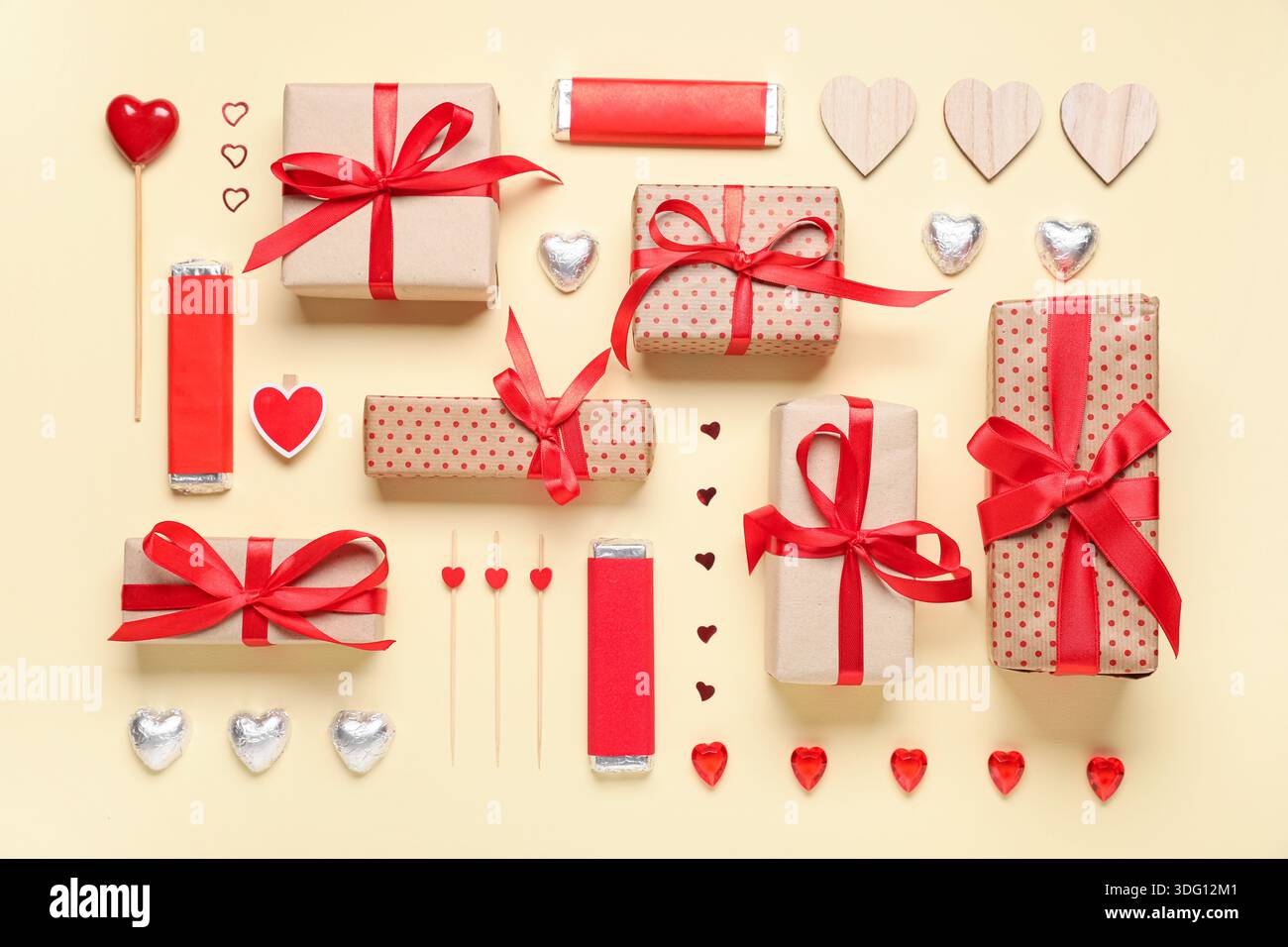 Boîtes cadeaux avec bonbons et coeurs décoratifs sur fond beige. Célébration de la Saint-Valentin Banque D'Images