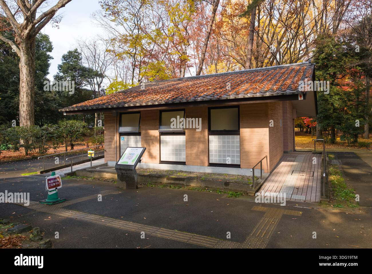 Nichées dans le jardin national de Kyoto Gyoen, ces toilettes japonaises traditionnelles offrent un répit serein aux visiteurs. Le bâtiment est simple, rectangulaire Banque D'Images