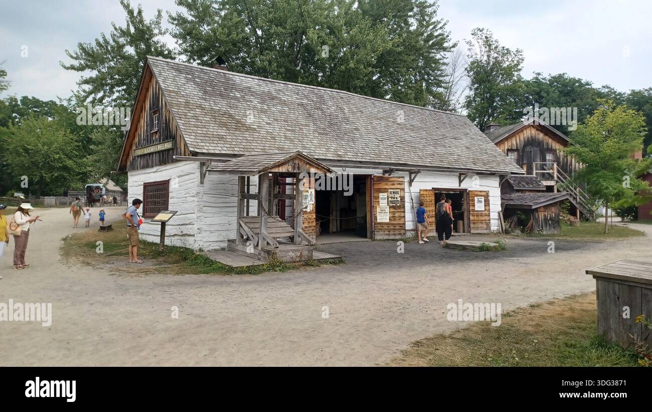 Morrisburg, ON, Canada - 3 août 2025 : ancien bâtiment en rondins au parc patrimonial du village d'Upper Canada, les visiteurs explorent le site historique et l'histoire locale Banque D'Images