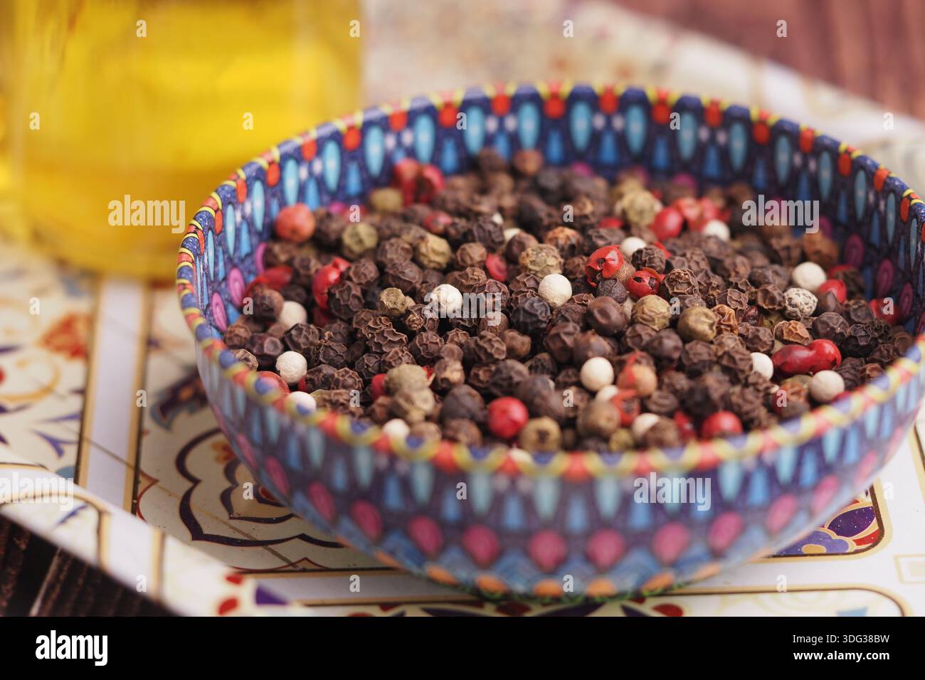 Bol de grains de poivre mélangés sur une table décorative Banque D'Images