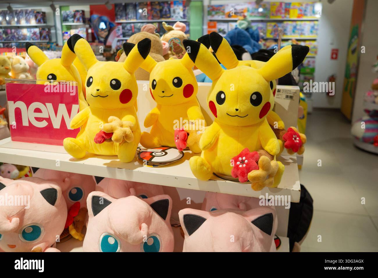 Jouets en peluche Pikachu de la franchise Pokémon exposés sur une étagère de vente au détail à l'intérieur d'un magasin de jouets, mettant en valeur les produits de personnages populaires. Banque D'Images