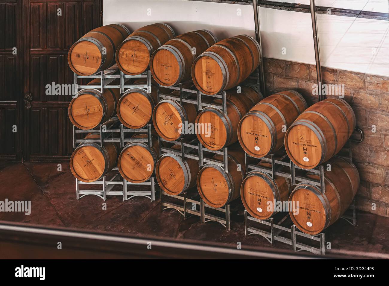 VENETS, BULGARIE - 08 OCTOBRE 2024 : fûts en bois de vin sur supports métalliques pour le vieillissement à long terme du vin avec logo. Fûts de chêne de marque avec Minkov Brothers Banque D'Images