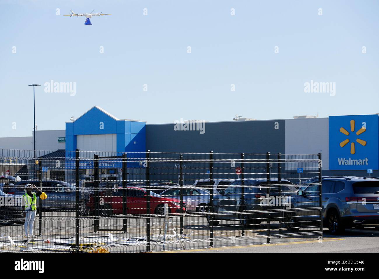 IMAGE DISTRIBUTED FOR WING DRONE DELIVERY - Shantell Udoessien, left, Operations Manager for Wing Drone Delivery in Texas, looks on after attaching a package for delivery onto the tether line of a hovering drone in the "Nest", a fenced off area for launching and recovering the drones in the parking lot of a WalMart on Wednesday, Jan. 14, 2026 in Houston. (Michael Wyke/AP Content Services for Wing Drone Delivery) Banque D'Images