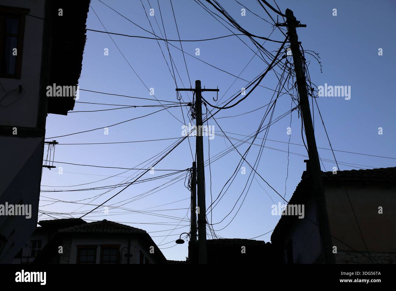 Fils enchevêtrés - câbles de ville contre le ciel à Berat, Albanie. Câbles électriques, câbles Internet et fils téléphoniques. Banque D'Images