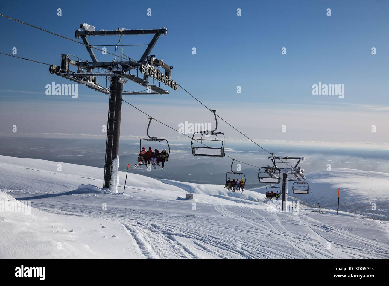 Les skieurs et les snowboarders prennent un télésiège jusqu'au sommet d'une montagne dans les montagnes Khibiny. Banque D'Images