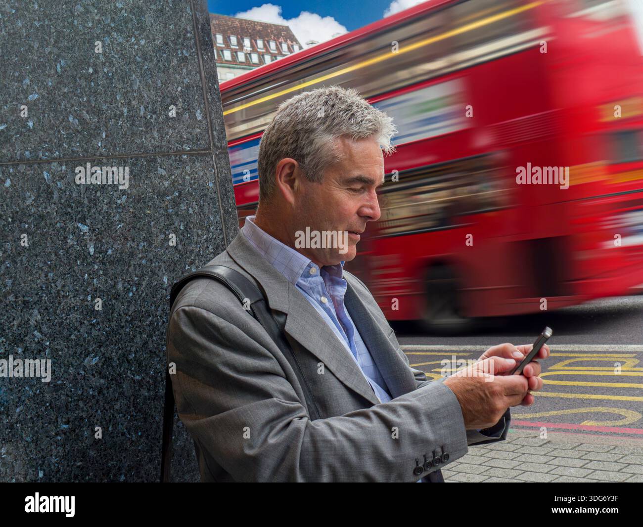 UBER TAXI APP TEXTE homme d'affaires mature 55-60 ans en utilisant smartphone Southbank central London bus rouge avec flou de vitesse passant en arrière-plan Londres UK TFL Banque D'Images