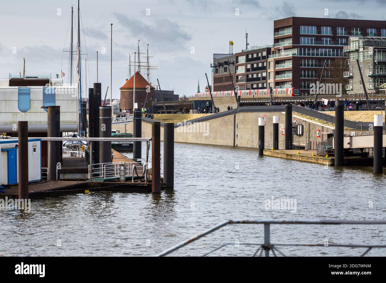 Hambourg, Allemagne – 21 février 2020 : les gens marchent le long de la promenade moderne de la rivière Niederhafen conçue par Zaha Hadid près de Baumwall avec vue sur le port et le rouge Banque D'Images