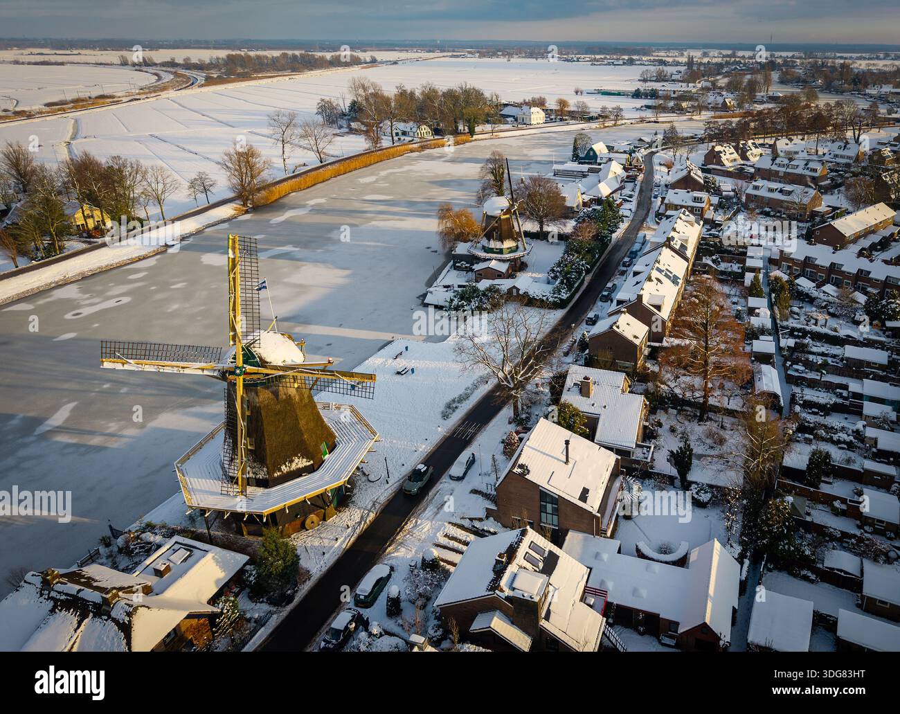 Vue aérienne hivernale de Weesp, pays-Bas, avec des moulins à vent historiques enneigés et la rivière Vecht Banque D'Images