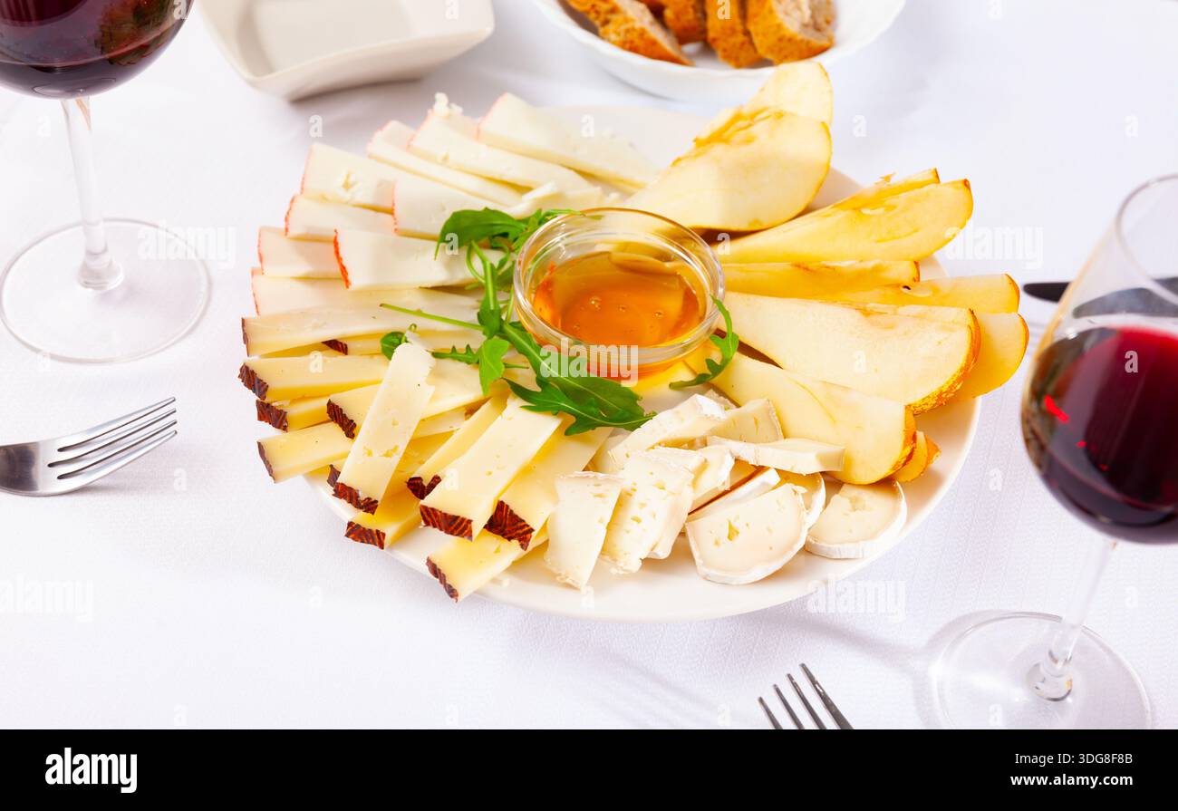 Différents types de fromage et de tranches de poire sur l'assiette Banque D'Images