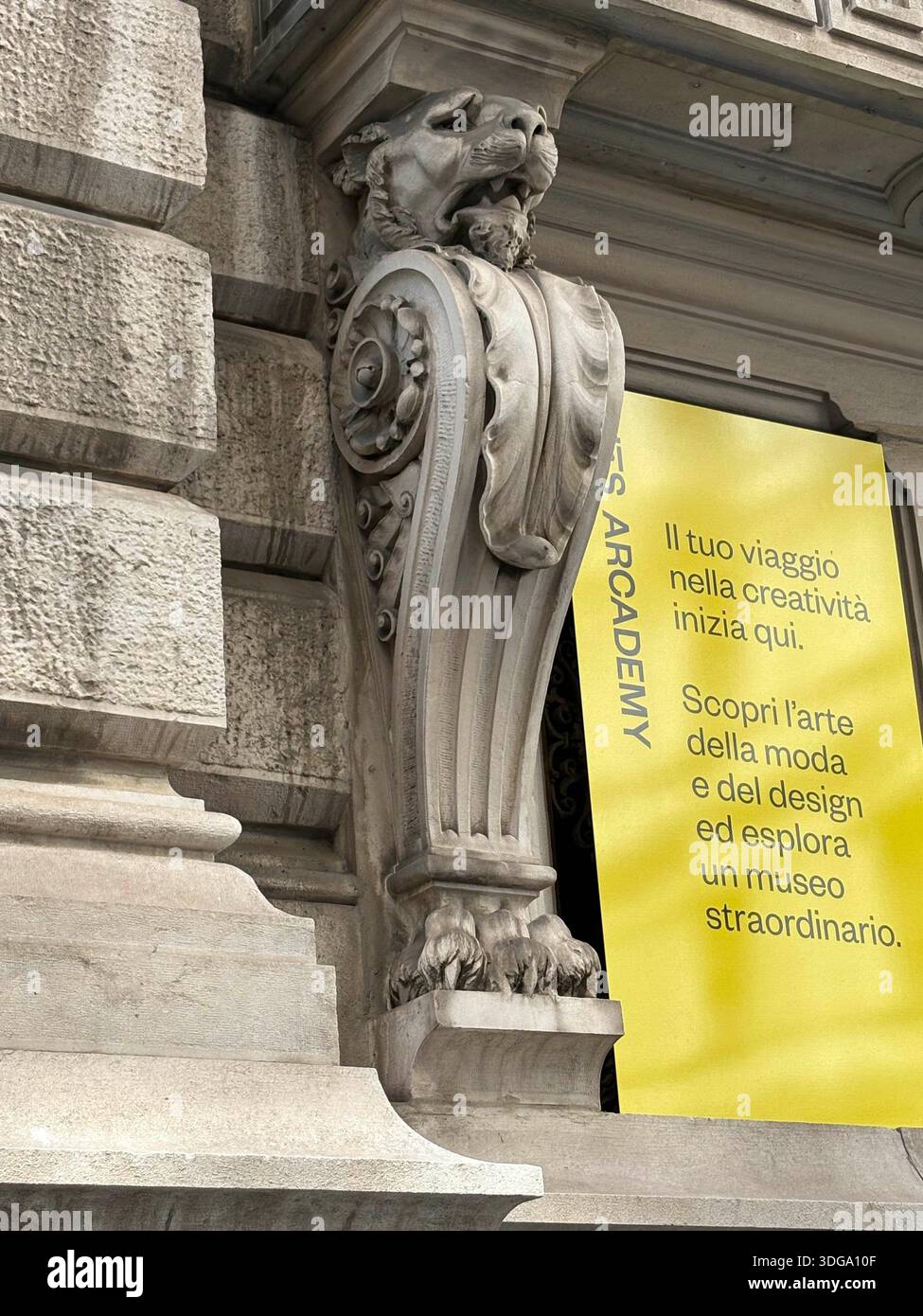 Corbeau de lion orné sur la façade historique de bâtiment en pierre en Italie, à côté de la bannière invitant à explorer la mode et le design - Image de stock capturée avec un smartphone
