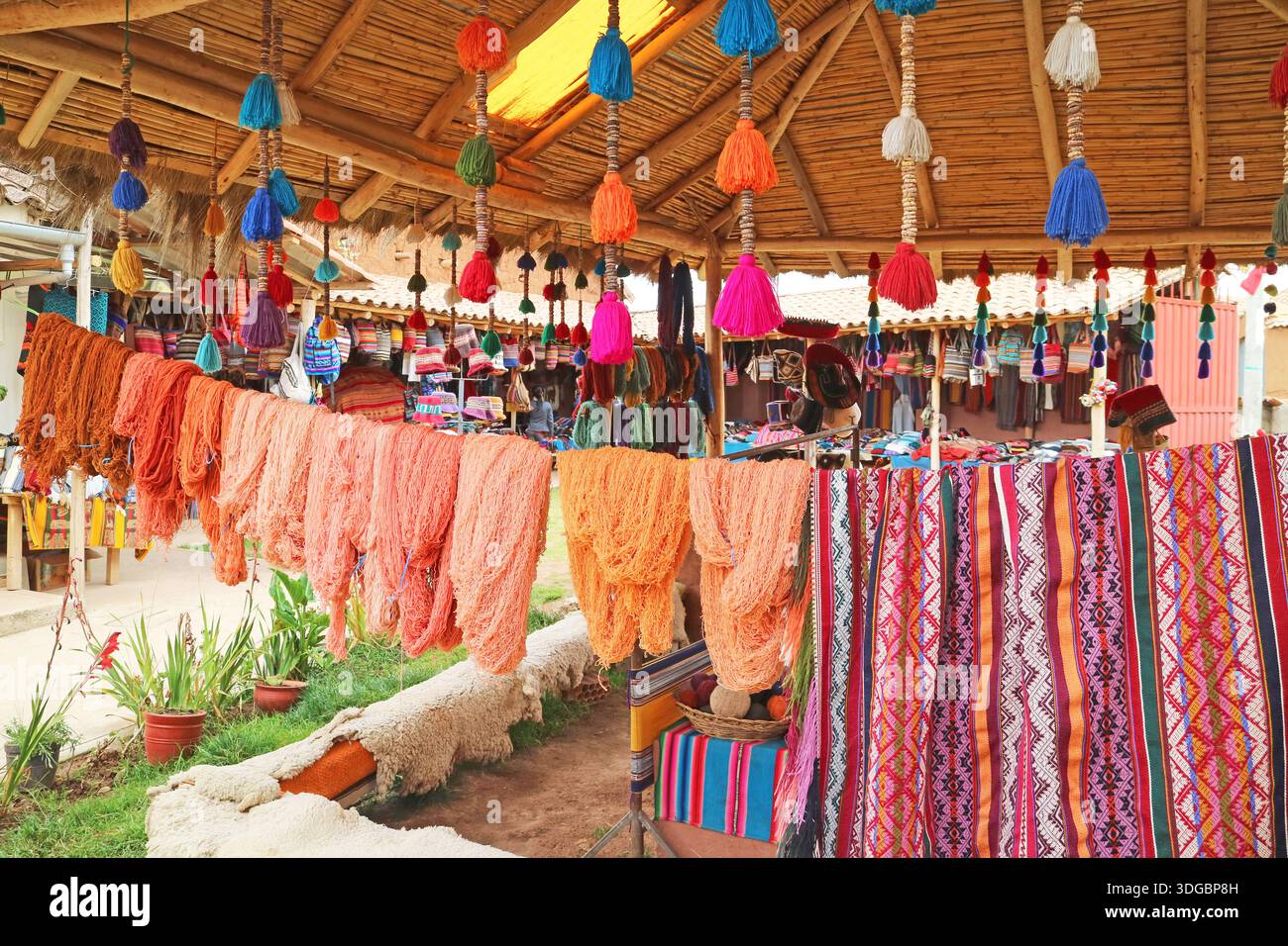 Des fils de laine teints naturels multicolores péruviens accrochés au village textile des Andes de Chinchero, région de Cuzco, Pérou, Amérique du Sud Banque D'Images