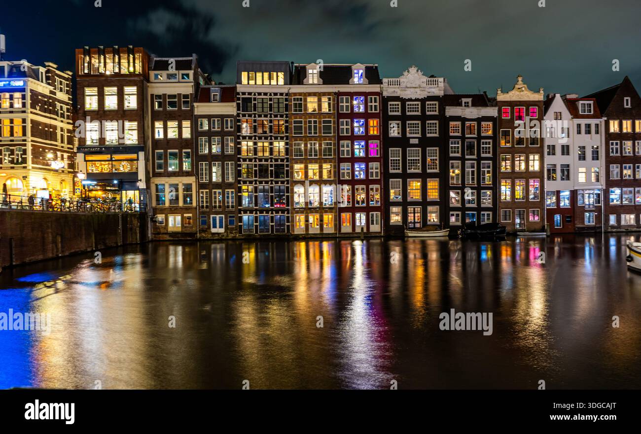 Maisons en rangée colorées le long du canal d'eau de nuit à Amsterdam pays-Bas Banque D'Images